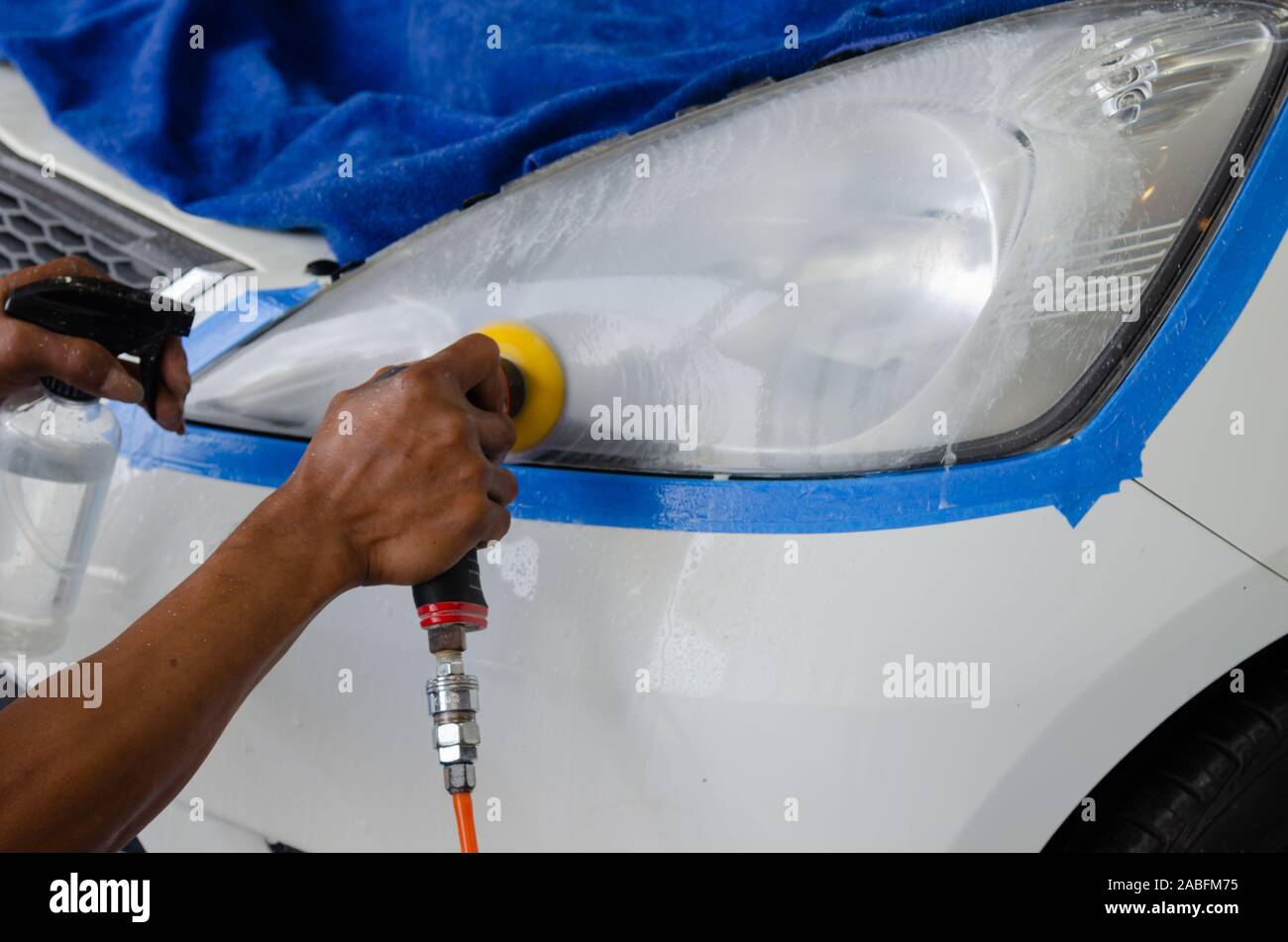 mechanic's hand is polishing the car's headlight Stock Photo Alamy