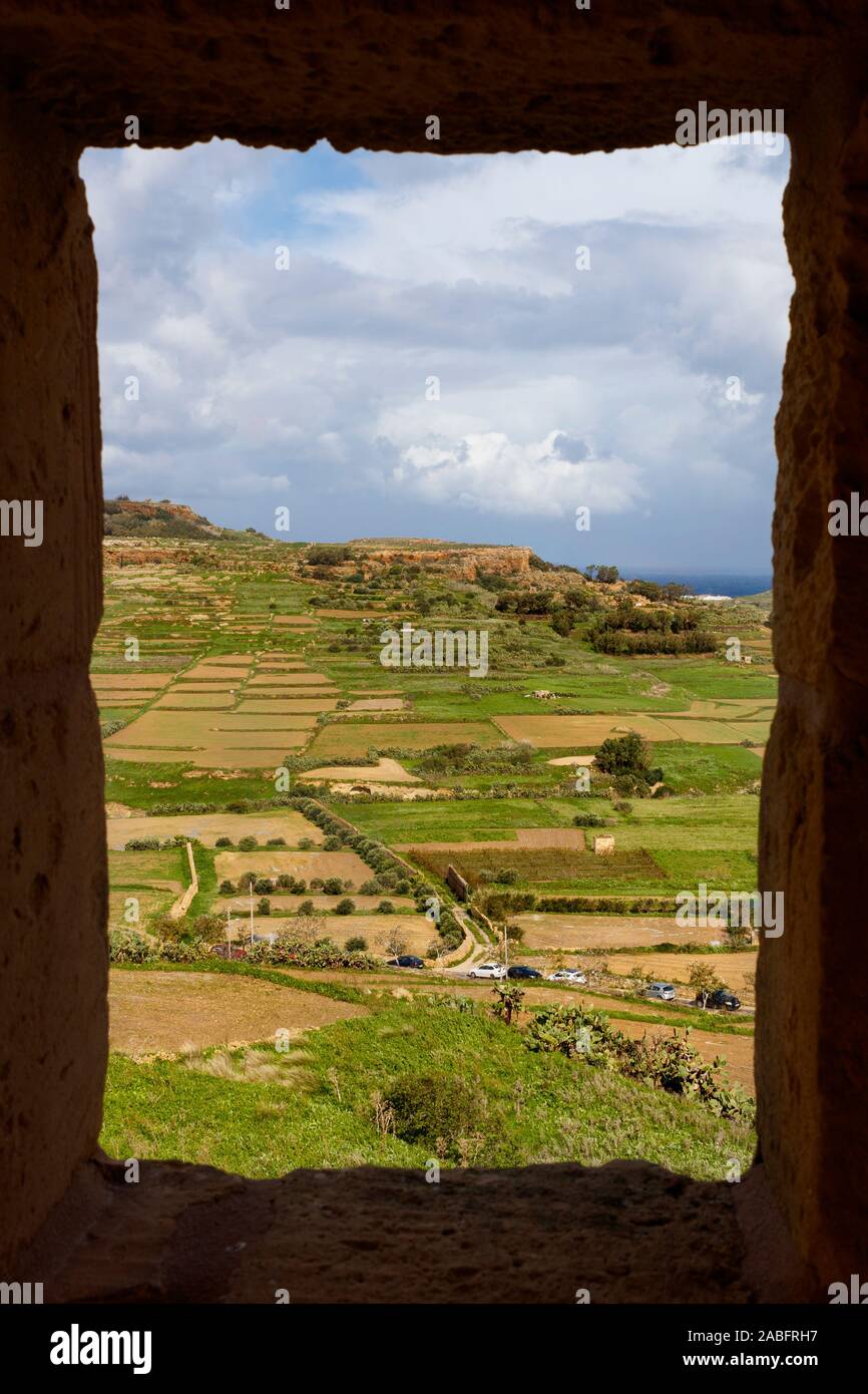 The landscape view to the Southeast of Gozo from the Citadel fortifications, Malta. Broken cloud given sunny areas across the patchwork farmland. Stock Photo