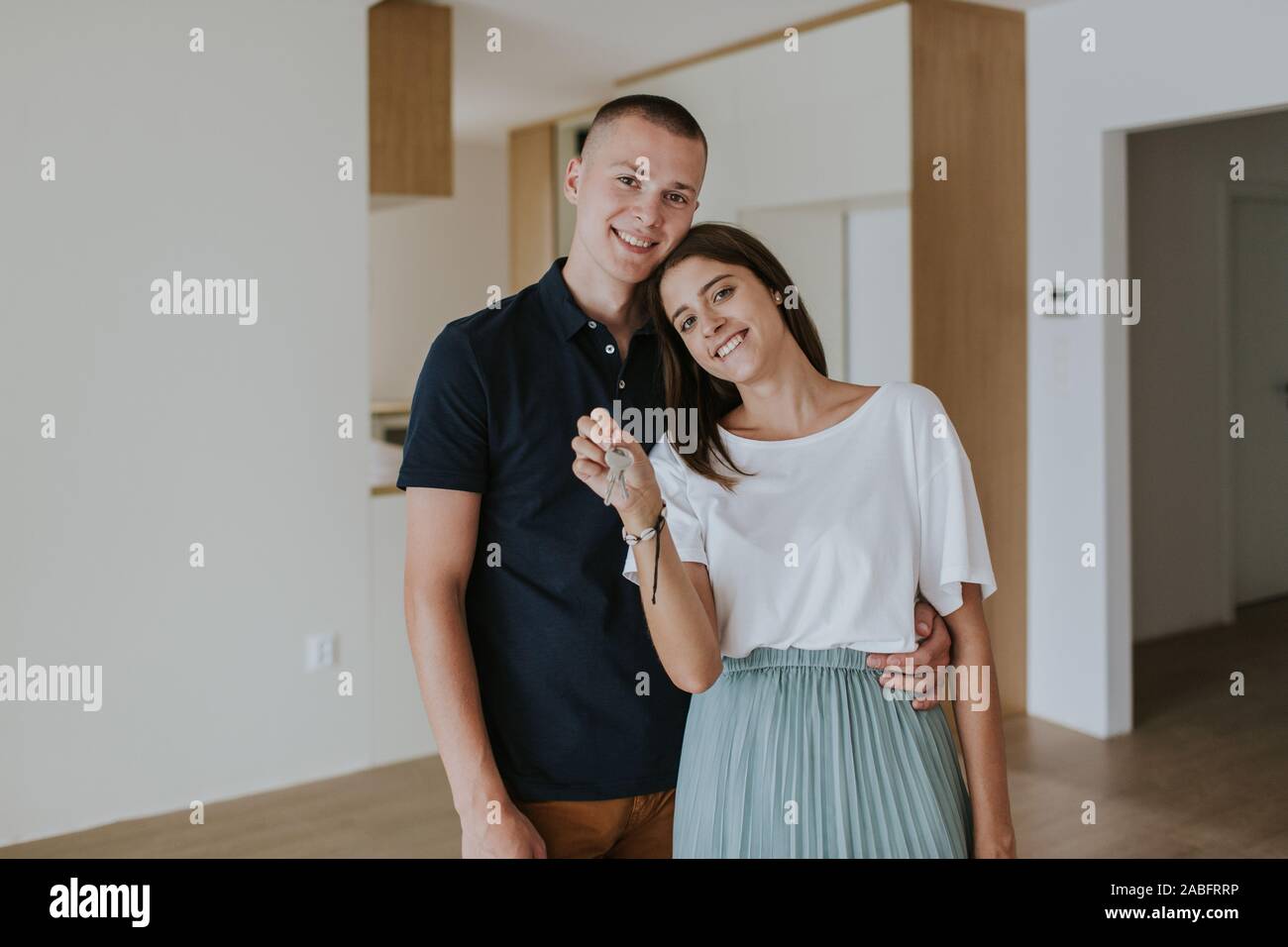 Cheerful young couple in new house holding keys Stock Photo - Alamy