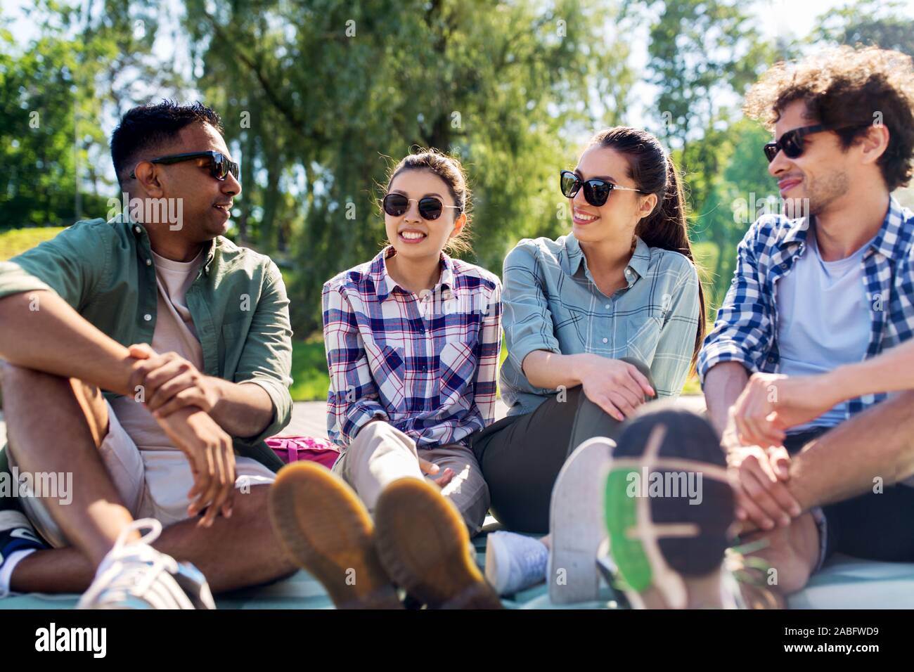 friends hanging out and talking outdoors in summer Stock Photo - Alamy