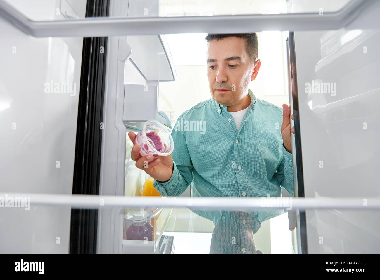 https://c8.alamy.com/comp/2ABFWHH/man-taking-empty-food-container-from-fridge-2ABFWHH.jpg