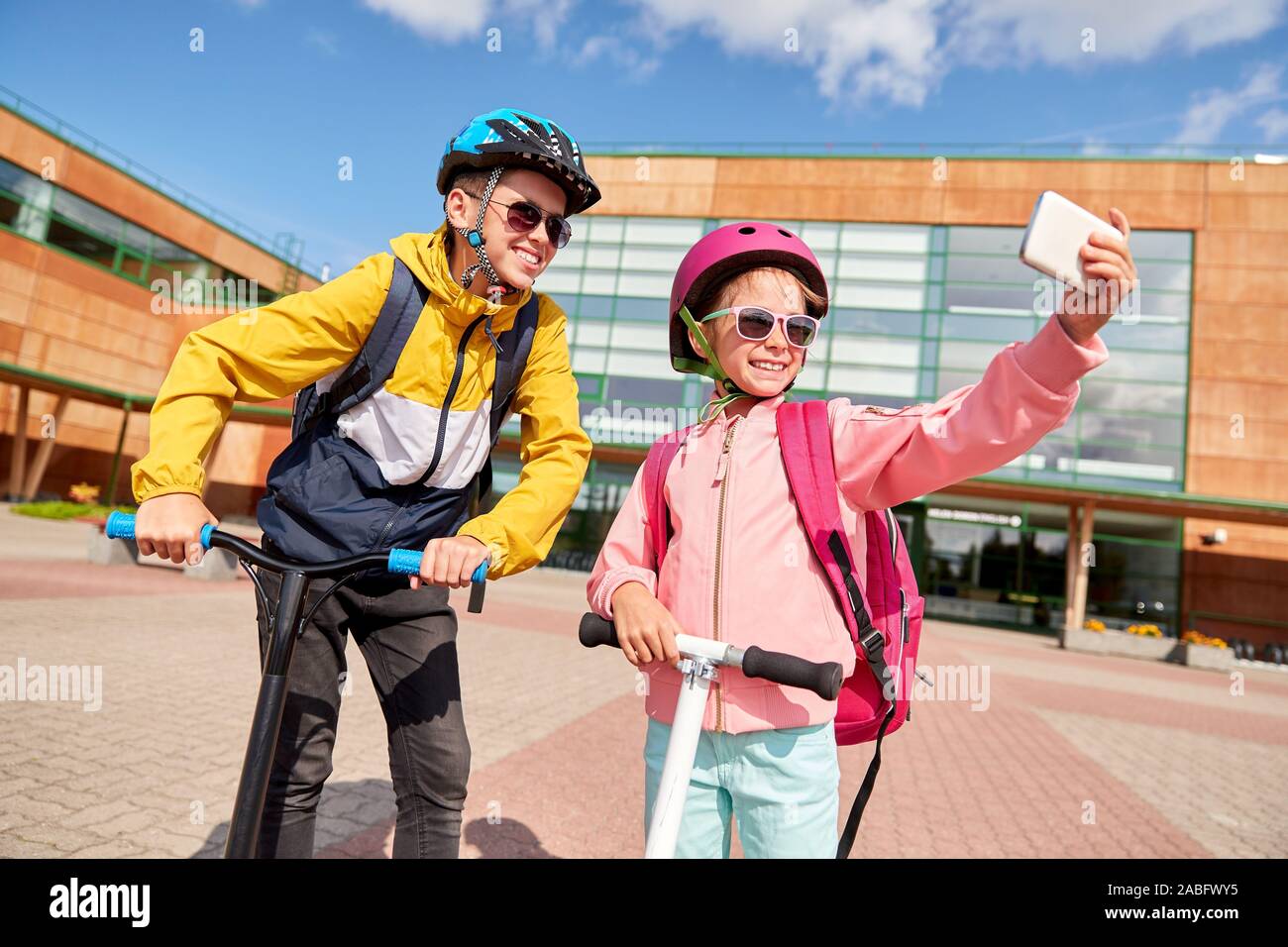 happy school kids with scooters taking selfie Stock Photo