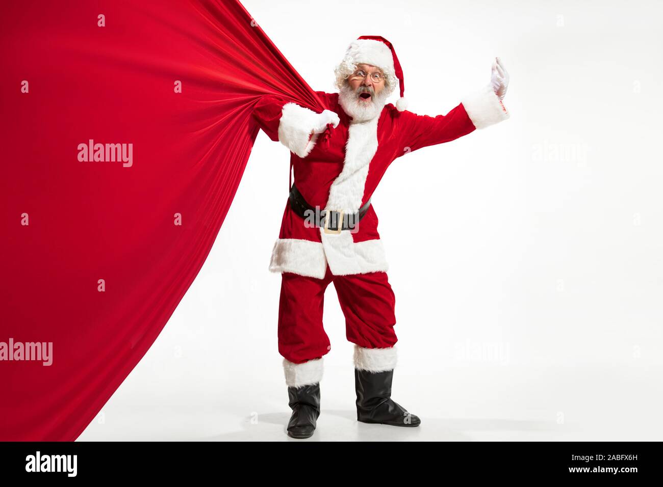 Santa Claus pulling huge bag full of christmas presents isolated on ...