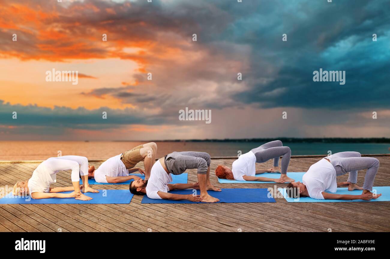 group of people making yoga exercises outdoors Stock Photo