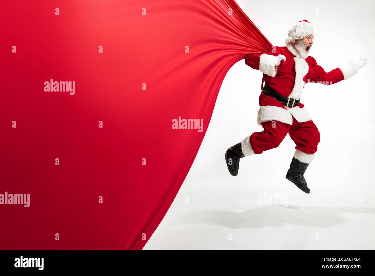 Santa Claus pulling huge bag full of christmas presents isolated on ...