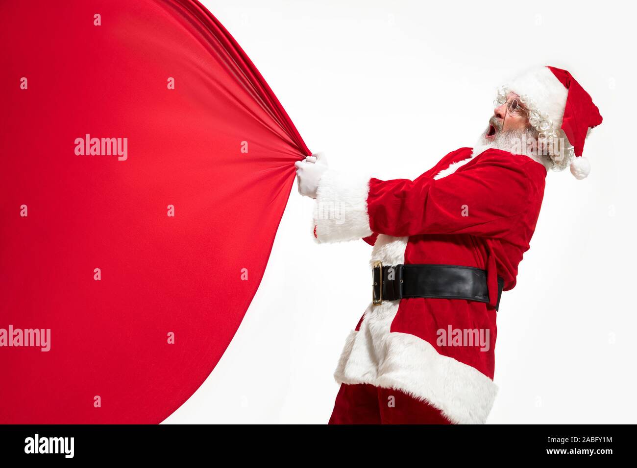 Santa Claus pulling huge bag full of christmas presents isolated on ...