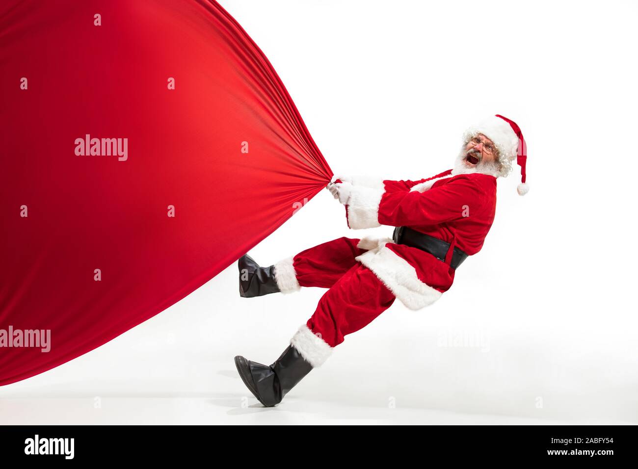 Santa Claus pulling huge bag full of christmas presents isolated on ...