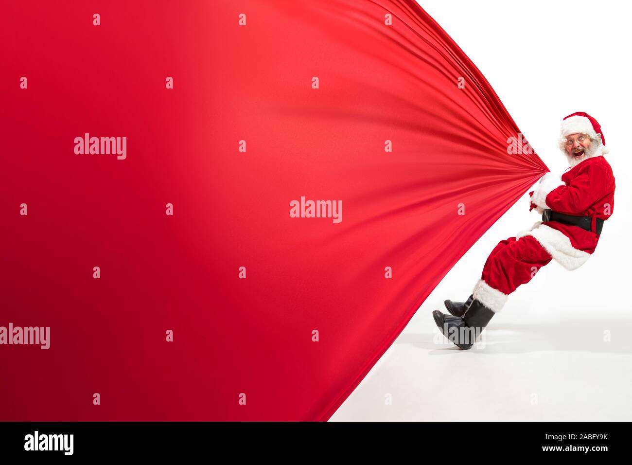 Santa Claus pulling huge bag full of christmas presents isolated on ...