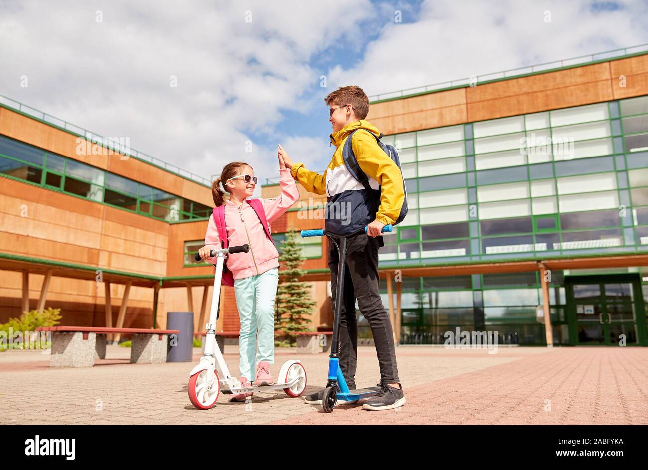 happy school children with backpacks and scooters Stock Photo Alamy
