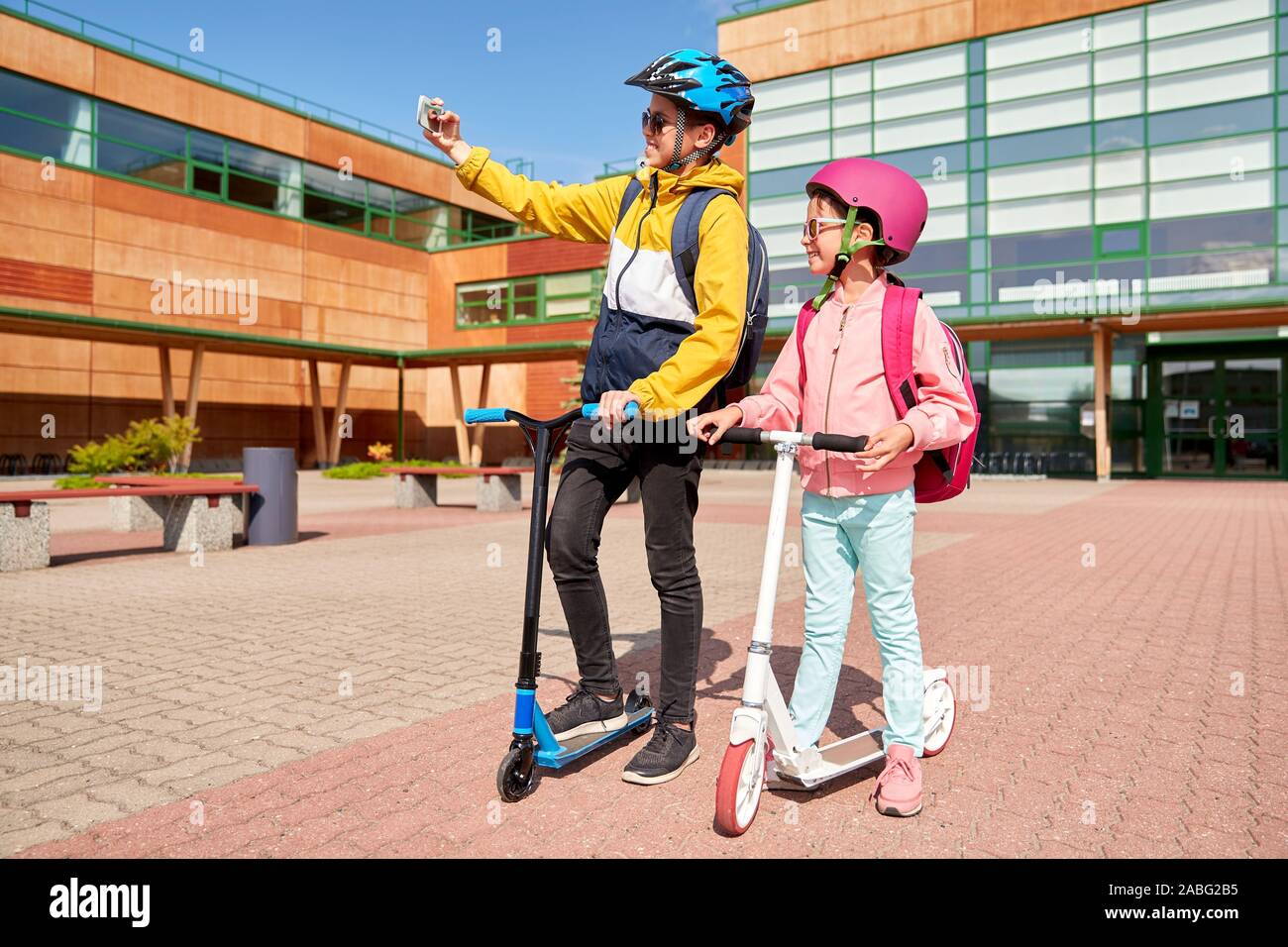 happy school kids with scooters taking selfie Stock Photo