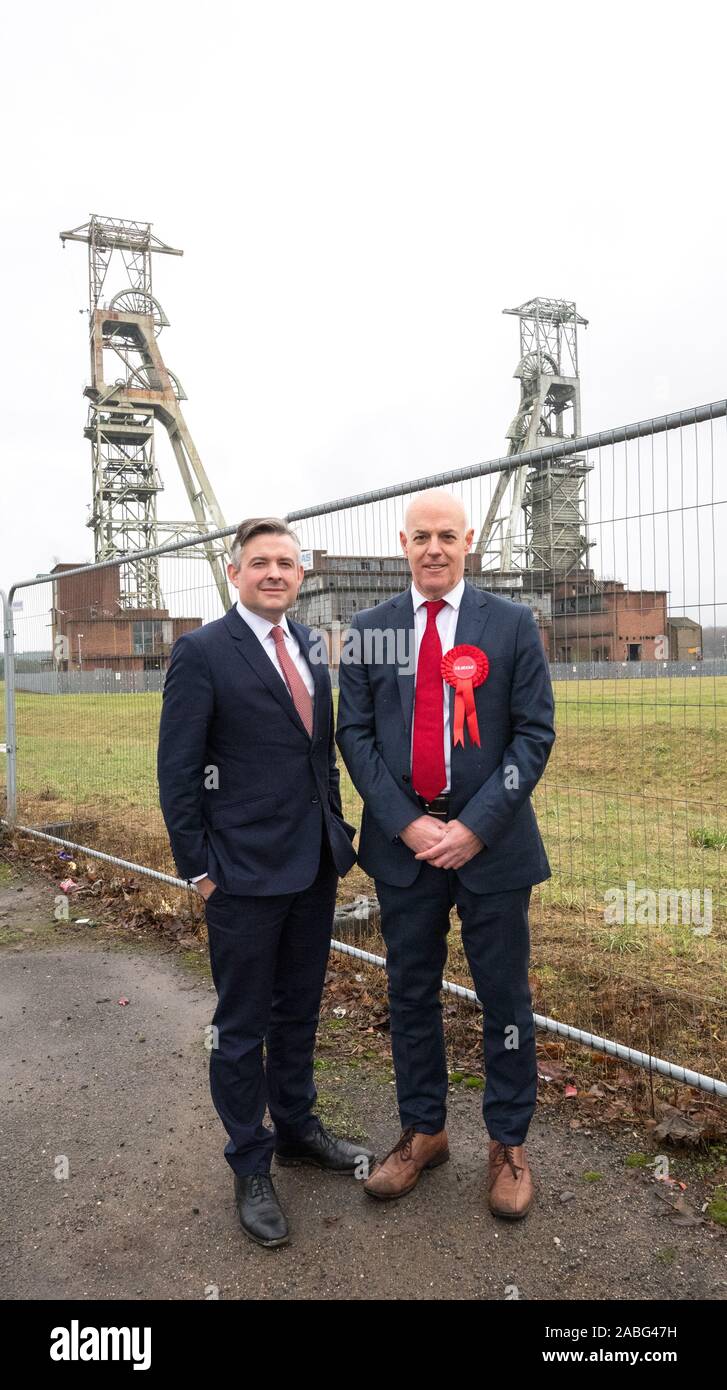 Clipstone, Nottinghamshire, England, UK. 27th. November 2019.  Jonathan Ashworth (Left) Labour's Shadow Secretary for Health and Jerry Hague (Right), Sherwood Labour Party candidate visiting the ex-mining community of Clipstone following Labour’s announcement on specialist lung clinics for retired miners. The only remaining building left standing of the colliery which was closed in 2003 are the grade II listed Headstocks, Europe’s tallest coal mining headstocks at over 200 feet. Credit:  Alan Beastall/Alamy Live News Stock Photo