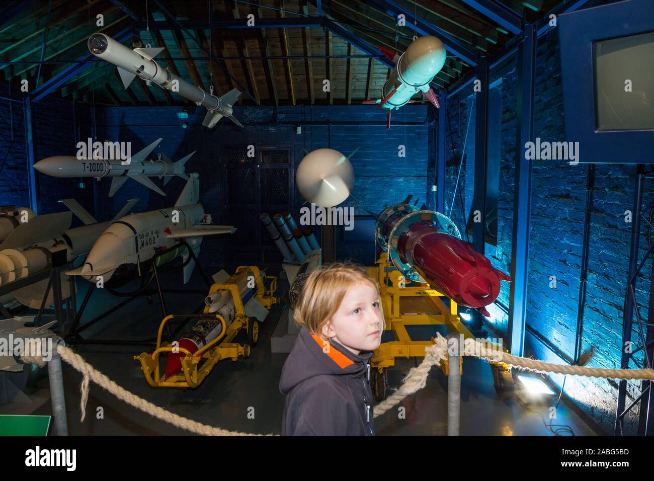 Arrangement display exhibition of vintage missiles and young girl tourist at the Explosion Museum of Naval Firepower; the Royal Navy's former armaments depot of Priddy's Hard, in Gosport. UK (105) Stock Photo