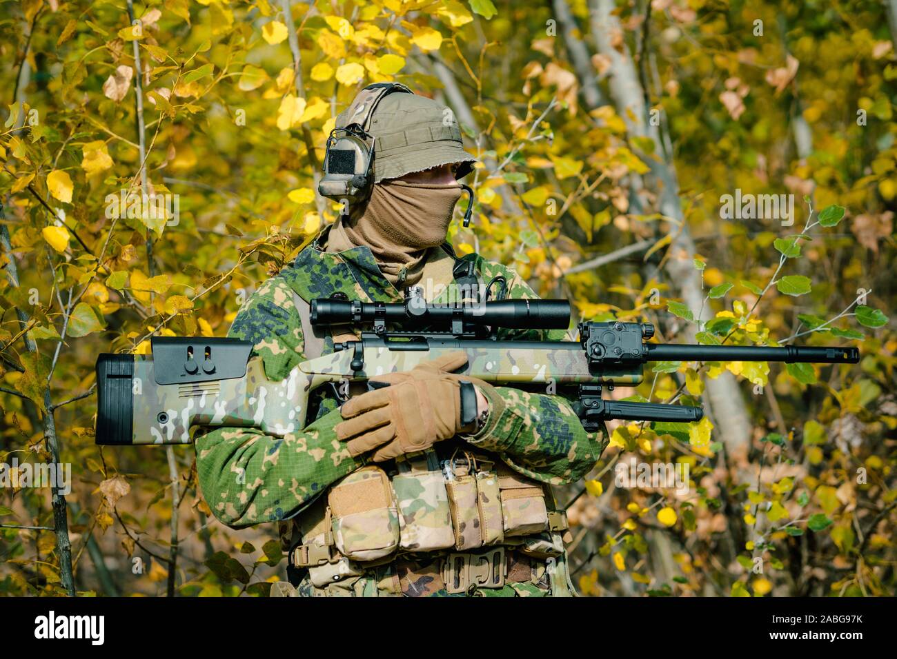 Airsoft man in uniform hold sniper rifle on yellow forest backdrop. Side  view Stock Photo - Alamy