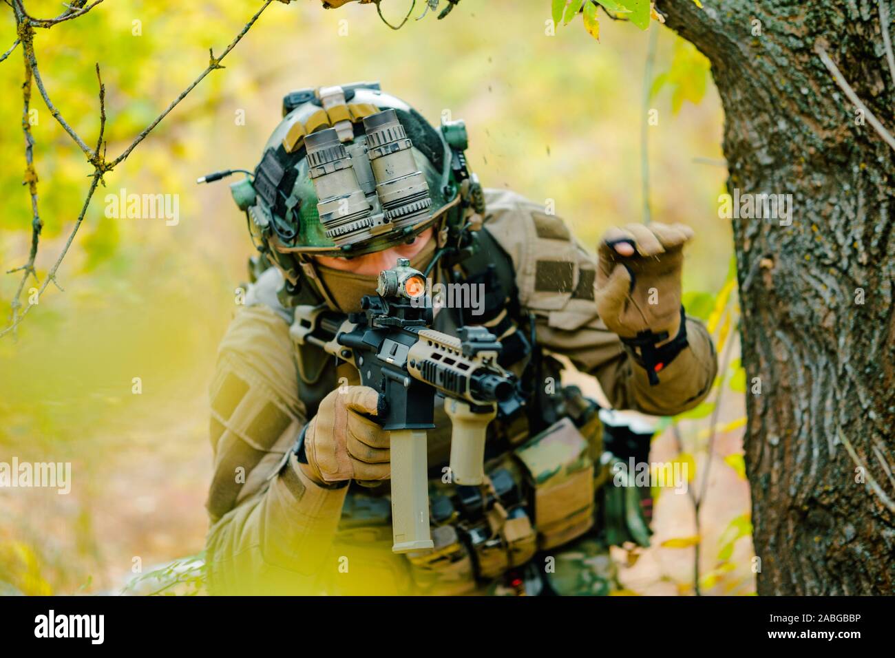 Airsoft man in uniform with machine gun and night-vision device on ...