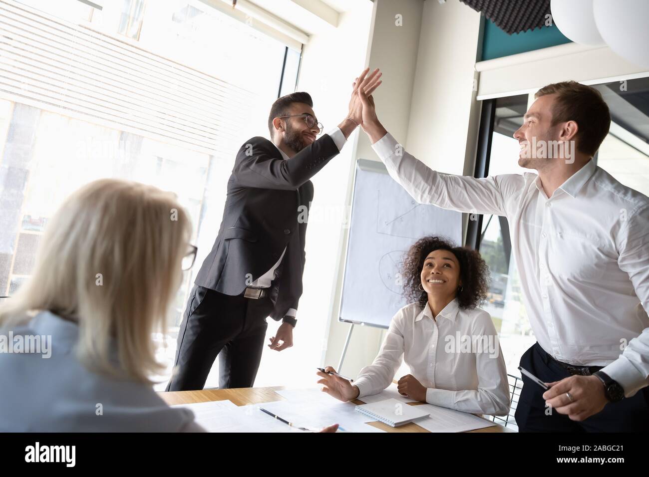 Excited male colleagues give high five celebrating shared success Stock ...