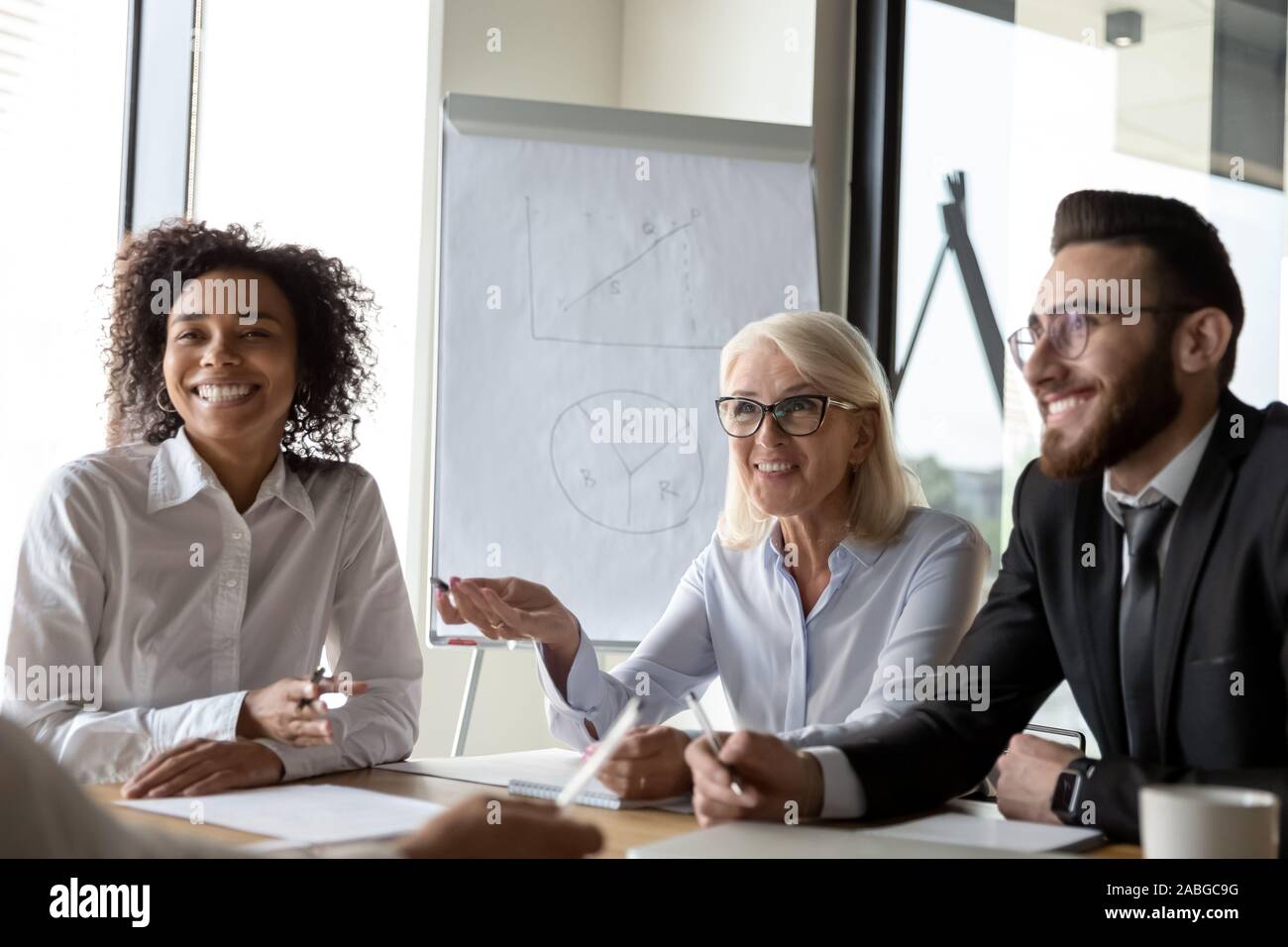 Smiling diverse colleagues laugh brainstorming at office briefing Stock ...