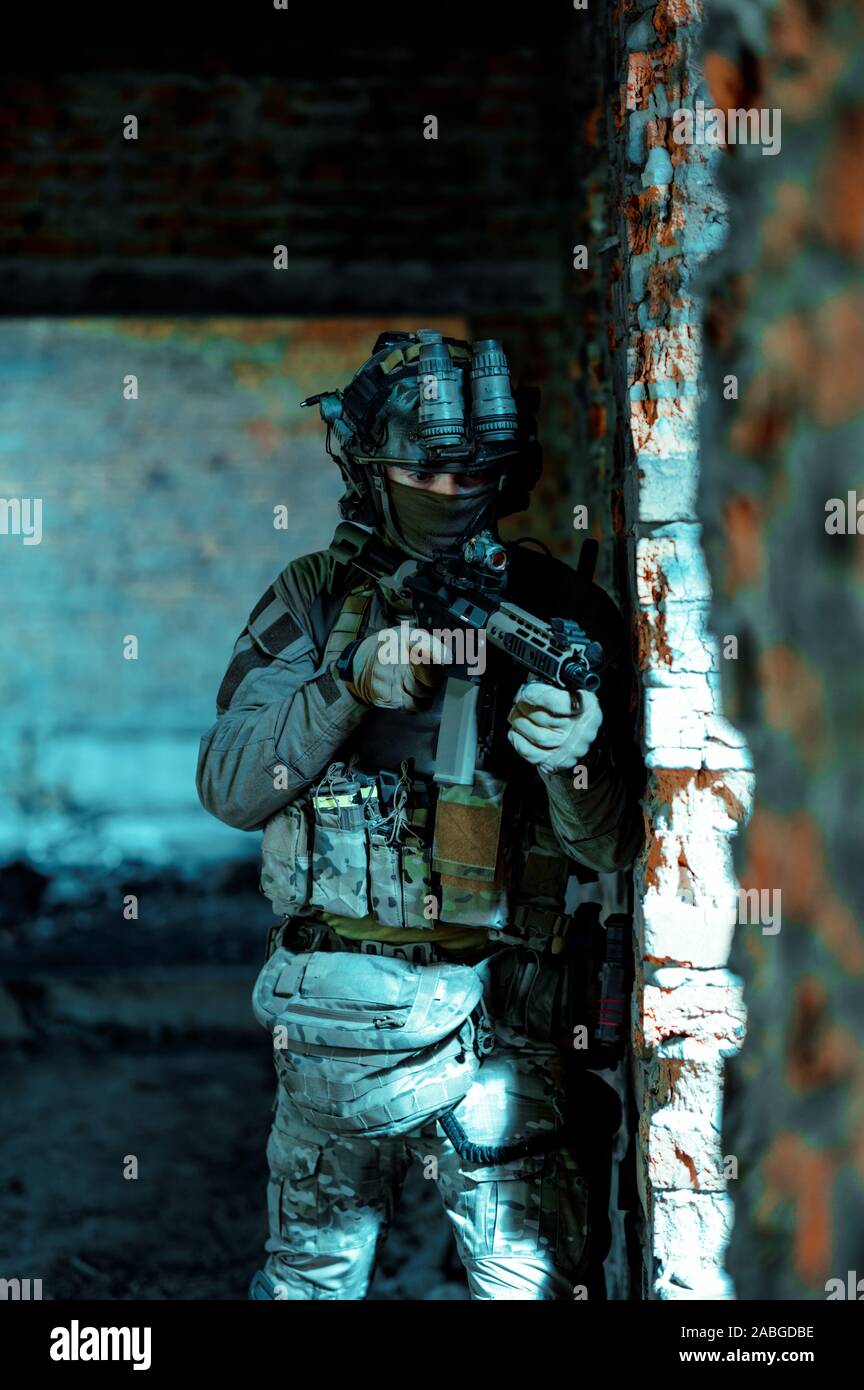 Airsoft man in uniform with machine gun and nightvision device on