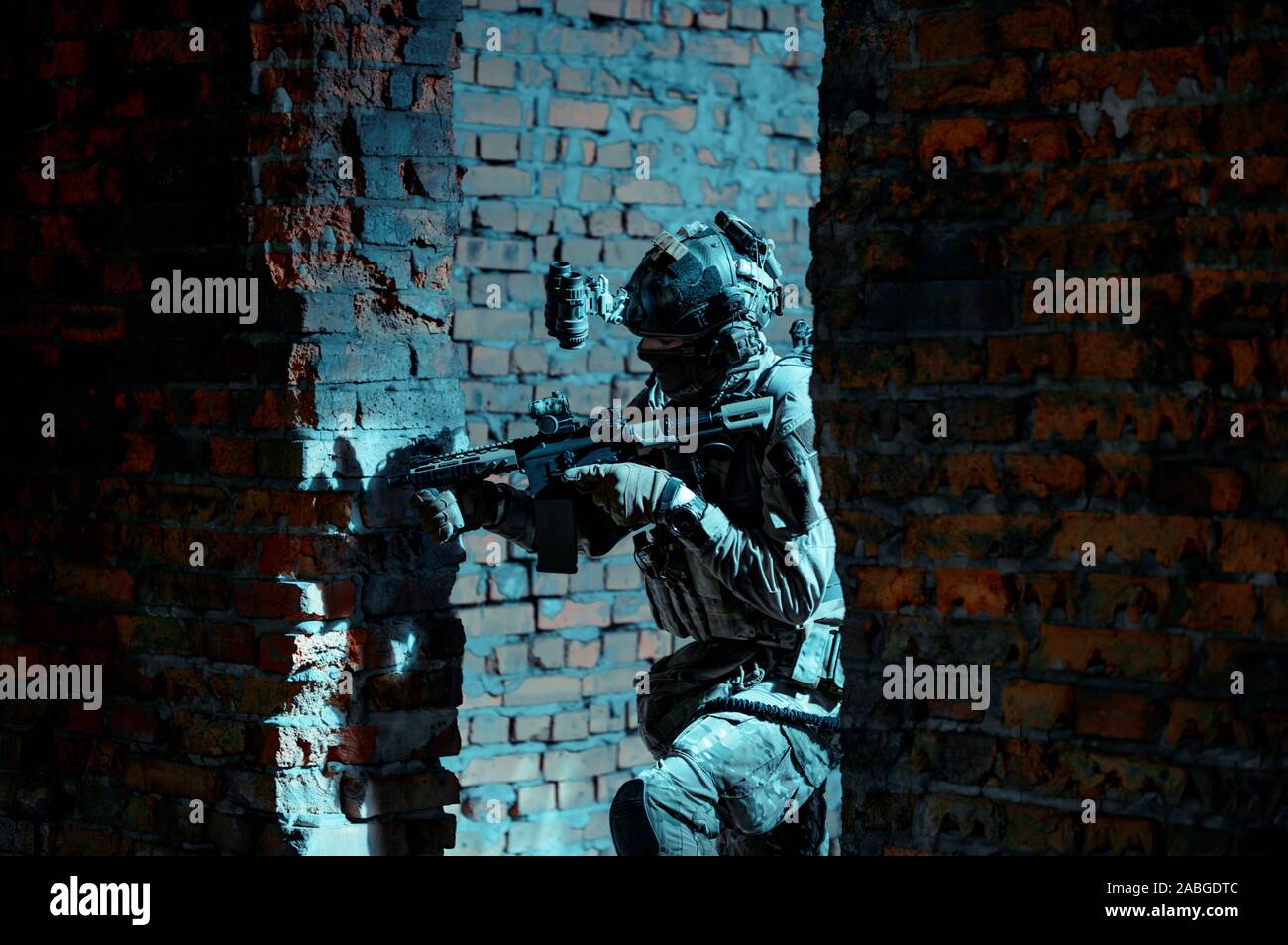 Airsoft man in uniform with machine gun and nightvision device on