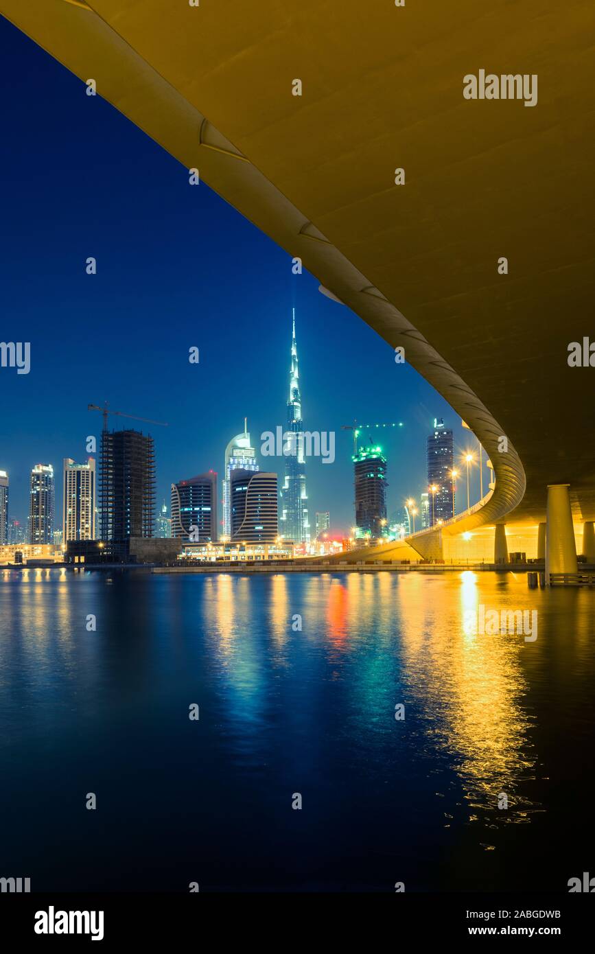 Night view of skyline of new Business Bay District towards Burj Khalifa tower  from The Creek river in Dubai United Arab Emirates Stock Photo