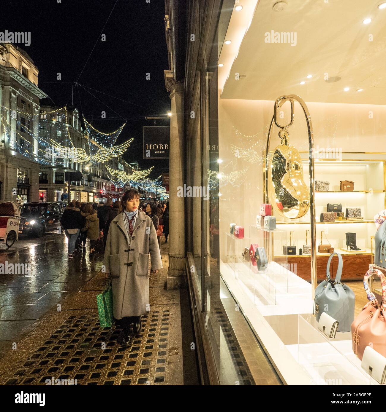 Lady browsing shops with the festive Angels behind, Regent Street, London. Stock Photo