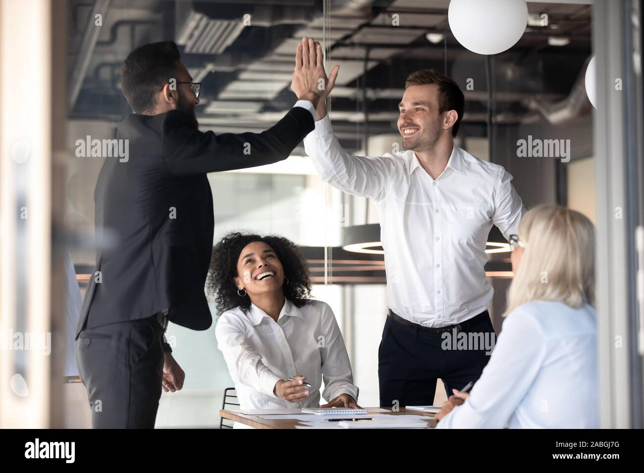 Excited male colleagues give high five celebrating shared success Stock ...