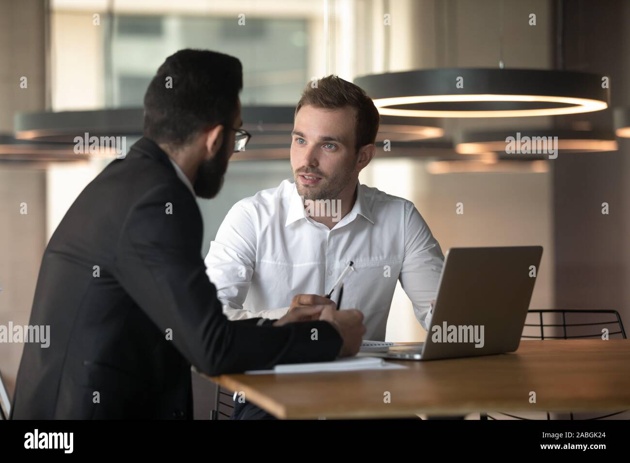 Young businessmen cooperating using laptop in office Stock Photo