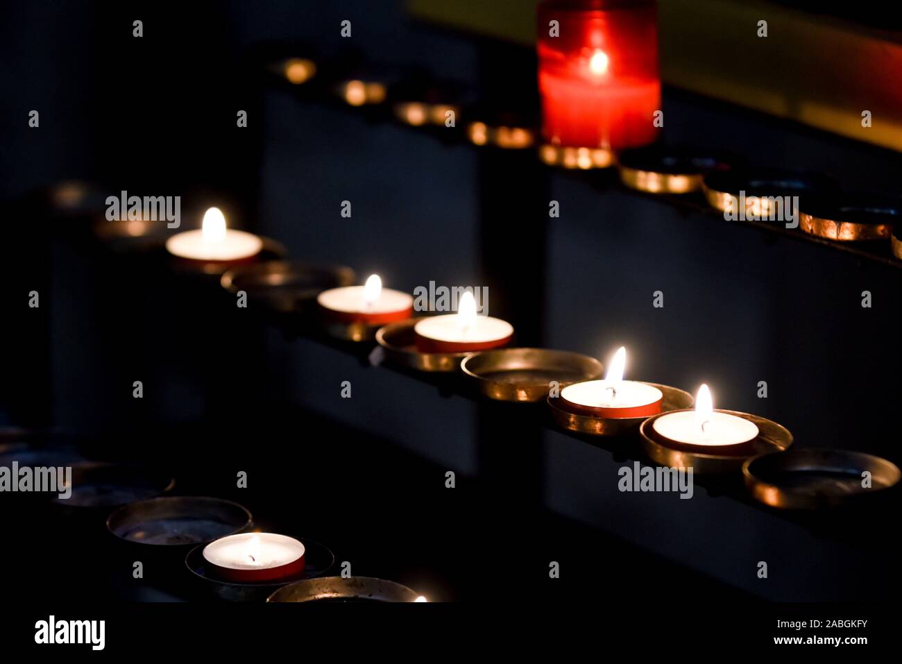 Prayer candles lit inside a church as a votive offering in an act or prayer Stock Photo Alamy