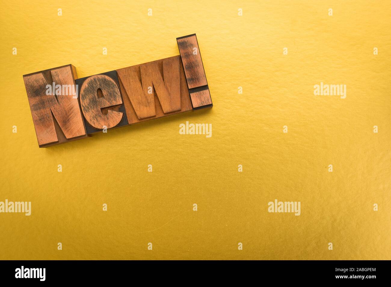 New! Word written with vintage letterpress printing blocks on gold colored background with copy space Stock Photo