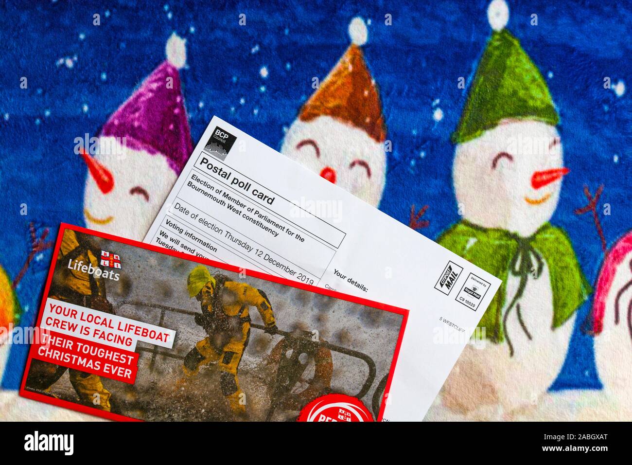 Post on Christmas mat including Postal Poll Card for forthcoming Parliamentary general election for 2019 in UK and RNLI Lifeboats Charity appeal Stock Photo
