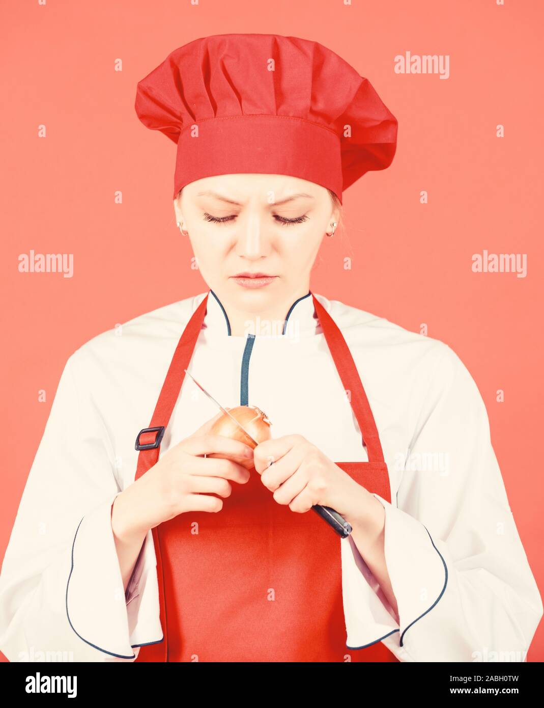 Girl cooking healthy meal. Housewife cook crying while cutting onion