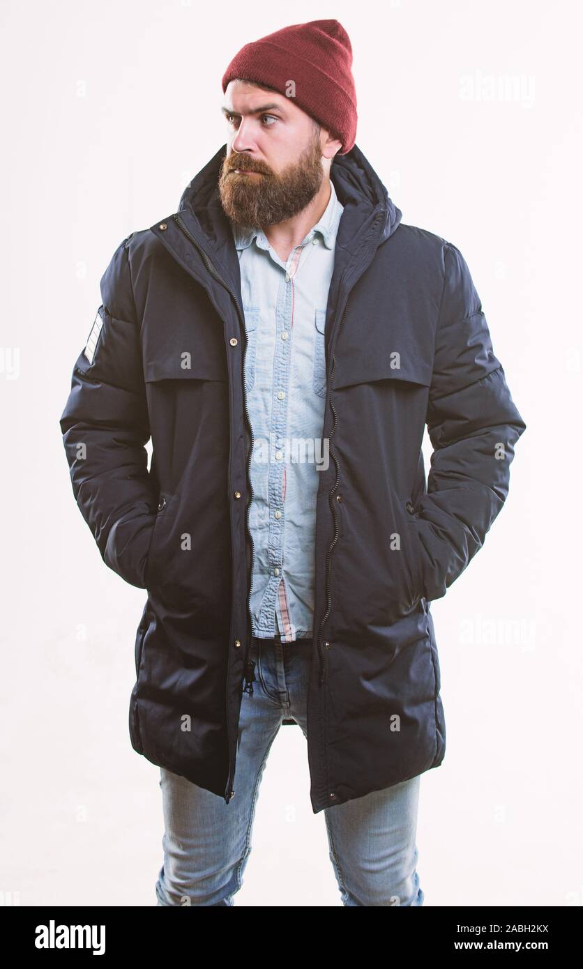 Guy wear hat and black winter jacket. Hipster style menswear. Hipster  outfit. Stylish and comfortable. Man bearded hipster posing confidently in  warm black jacket or parka. Hipster modern fashion Stock Photo -
