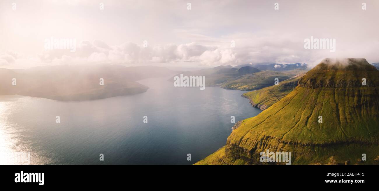 Foggy mountain peaks and clouds covering sea and mountains. Panoramical view from famous place - Sornfelli on Streymoy island, Faroe islands, Denmark. Landscape photography Stock Photo