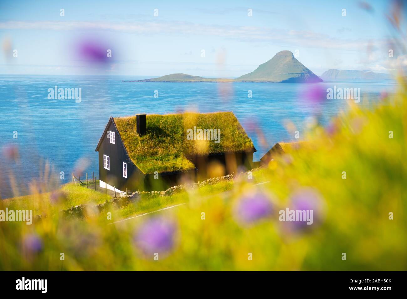 Foggy morning view of a house with typical turf-top grass roof in the Velbastadur village on Streymoy island, Faroe islands, Denmark. Landscape photography Stock Photo