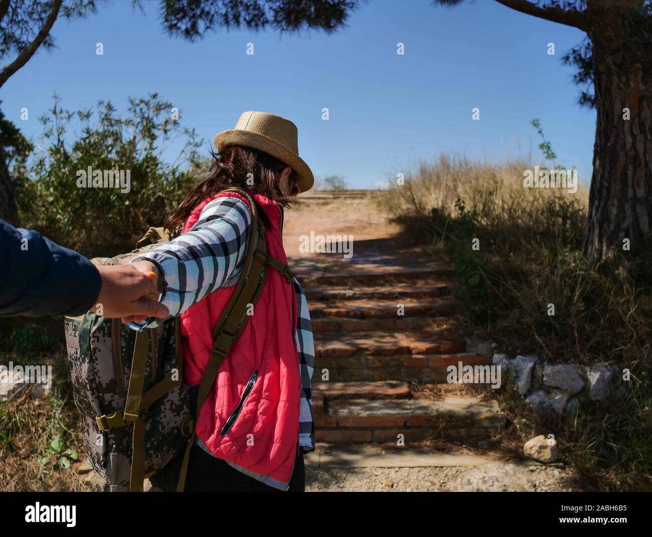 Girl tourist with a backpack leads along the trail Stock Photo