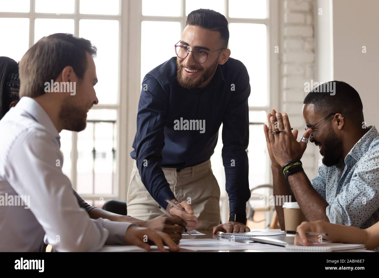 Happy young manager having fun with mixed race colleagues. Stock Photo