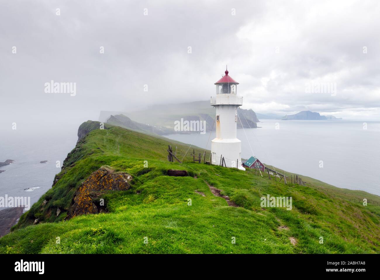 Foggy view of old lighthouse on the Mykines island, Faroe islands, Denmark. Landscape photography Stock Photo