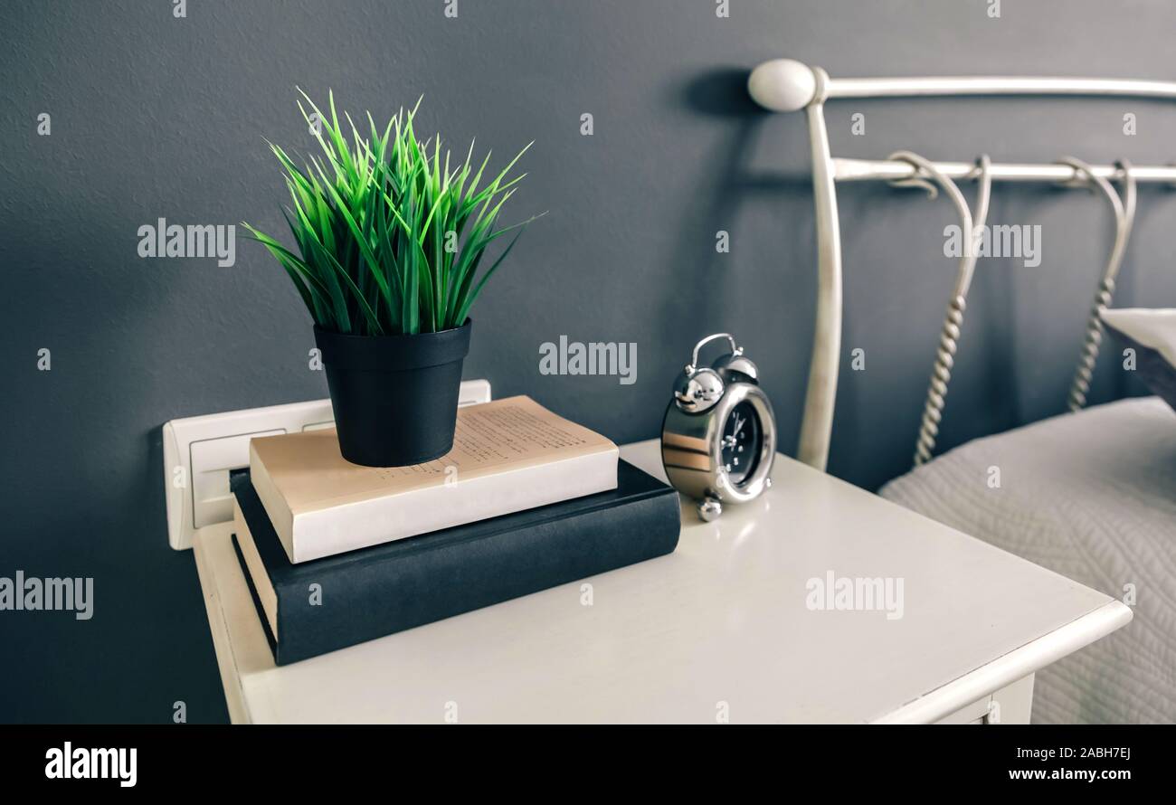 Bedside table with books and plant Stock Photo