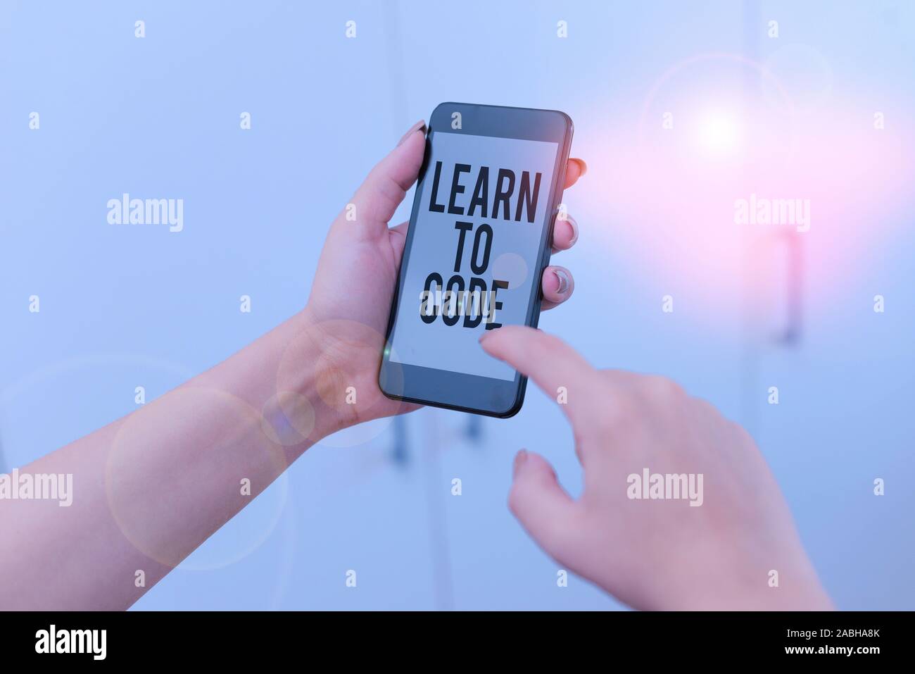 Word writing text Learn To Code. Business photo showcasing Learn to write Software Be a Computer Programmer Coder woman using smartphone office suppli Stock Photo
