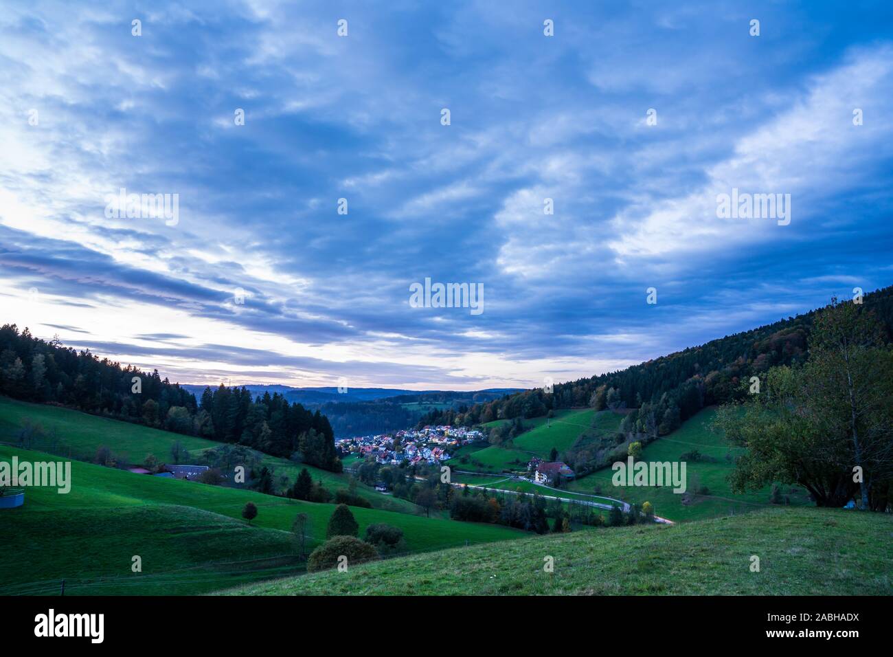 Germany, Black forest village idyl, elzach houses and streets in valley surrounded by conifer trees at sunset, view above green hills after sunset Stock Photo