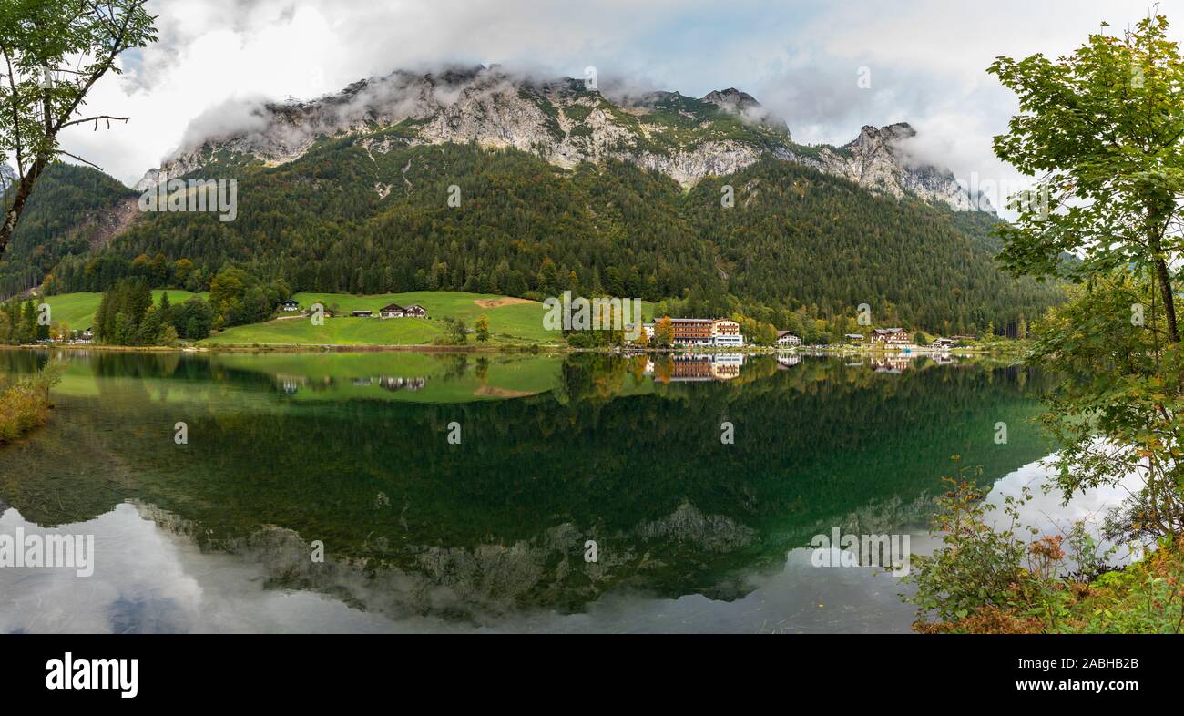 Panorama view of Hintersee with beautiful reflections of trees and houses and the Alps in background, near Konigssee lake, Ramsau in Berchtesgaden, Ba Stock Photo