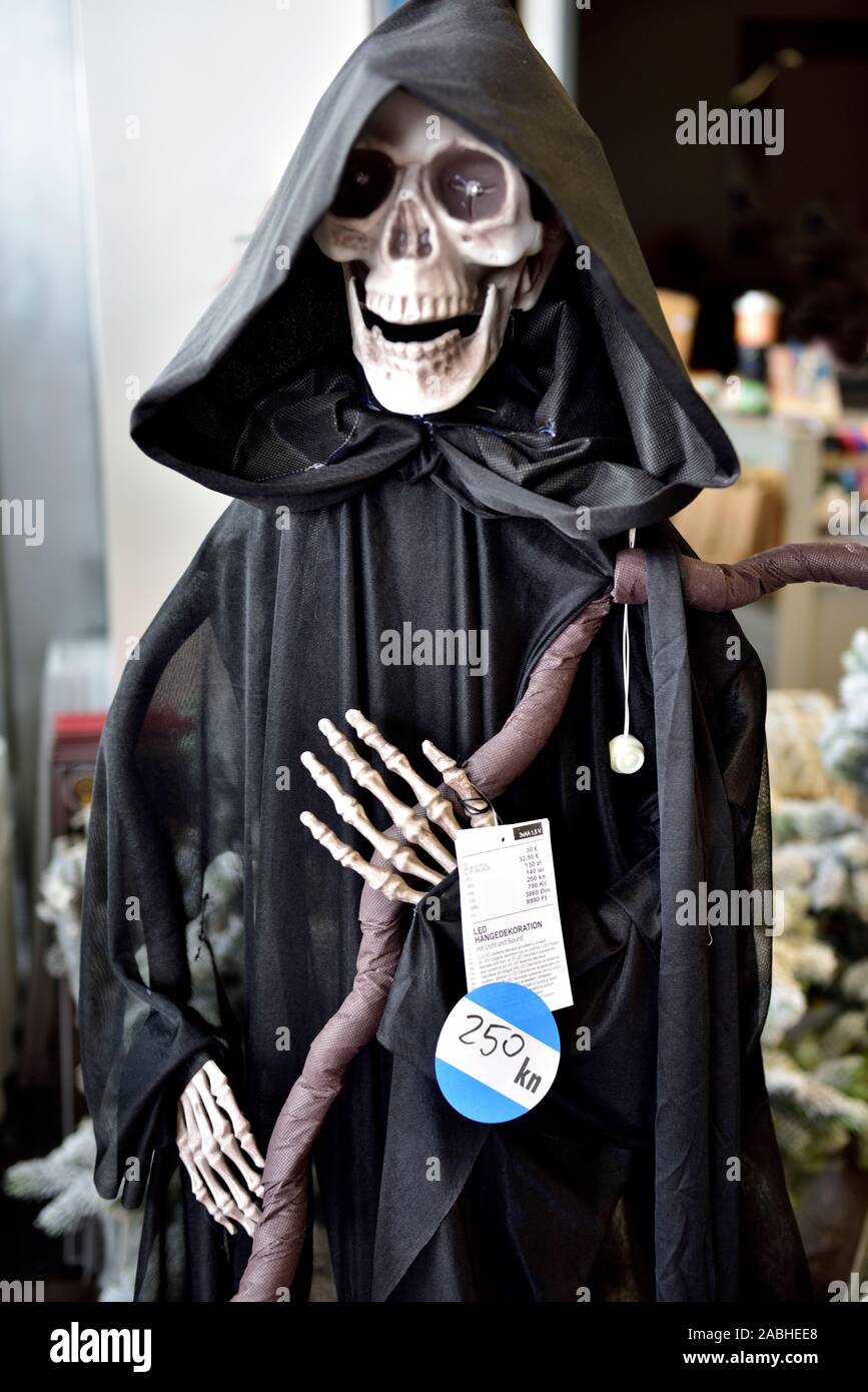 Halloween grim reaper skeleton decoration in black cloak display for sale in shop Stock Photo