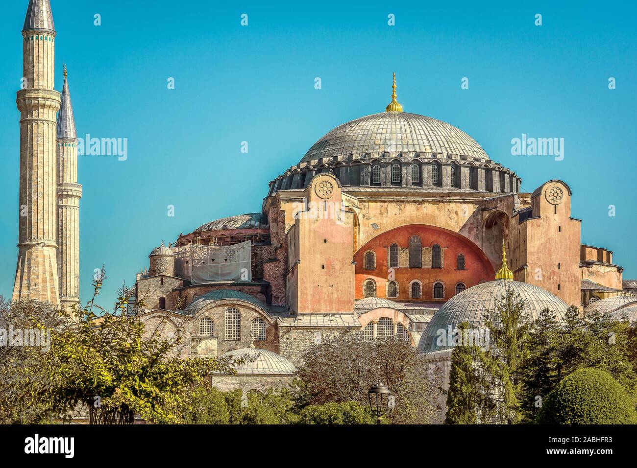 The facade of Hagia Sophia with two minarets and its huge cupola against the blue sky. Hagia Sophia was a Byzantine cathedral and Ottoman mosque built Stock Photo