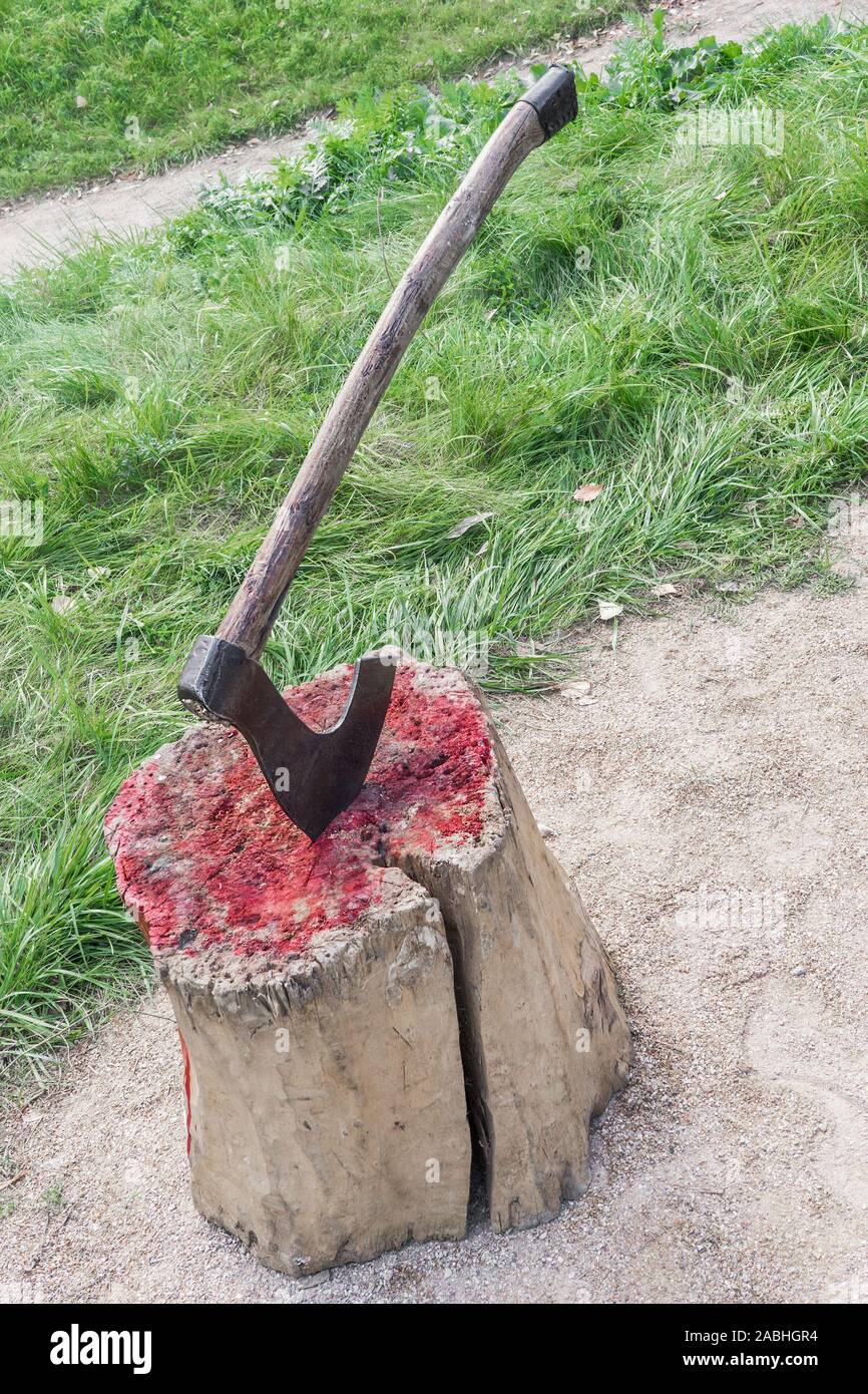 Bloody wooden stump at place of execution of defendant. Axe of executioner from middle Ages. Murder weapon. Kind of massacre of ancient centuries. Stock Photo