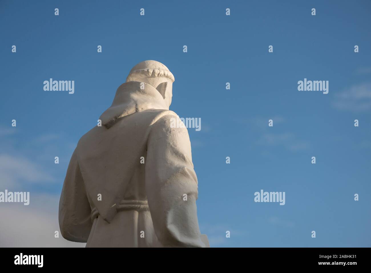 Religious figure statue of a friar monk back wearing Franciscan habit robe Stock Photo