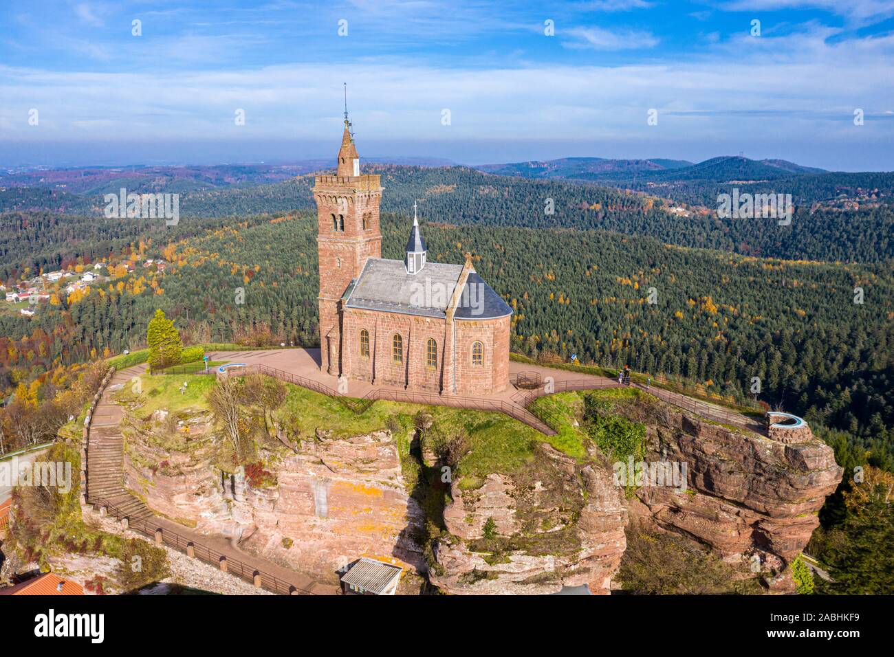 Beautiful autumn aerial view of St. Leon chapel dedicated to Pope Leo IX atop of Rocher de Dabo or Rock of Dabo, red sandstone rock butte, and Moselle Stock Photo