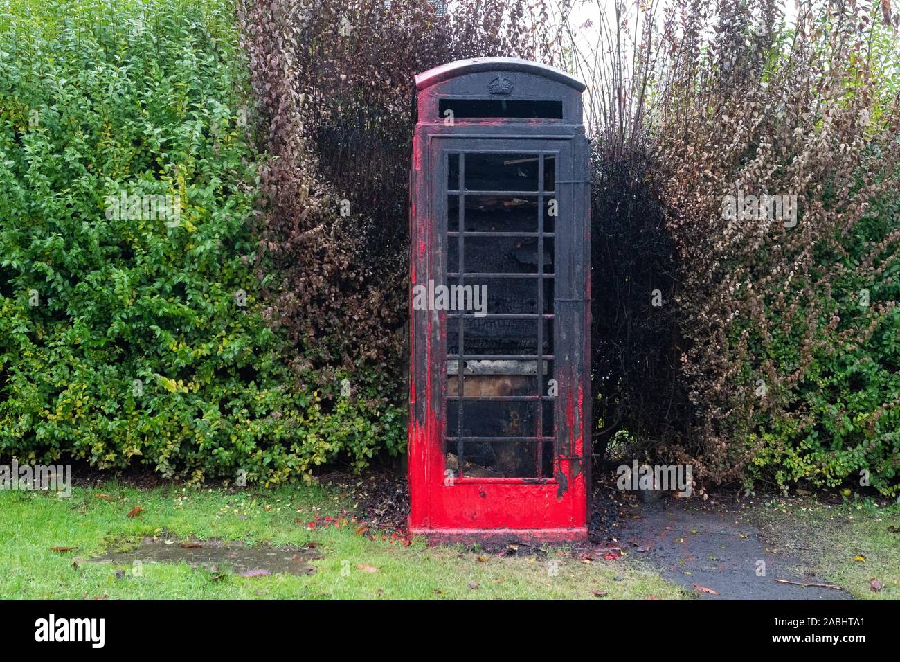 anti social behaviour - burnt out red telephone box in the South Yorkshire village of Barnburgh, that was being used as a village library Stock Photo
