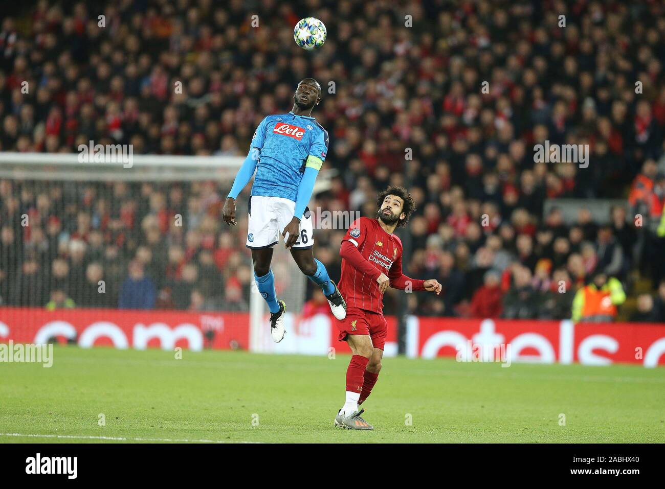 Liverpool UK. 27th Nov 2019. Kalidou Koulibaly of Napoli jumps and heads the ball while Mohamed Salah of Liverpool looks on. UEFA Champions league group E match Liverpool v Napoli at Anfield