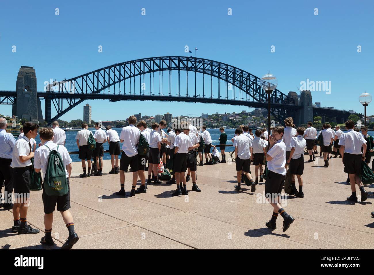 Sydney schoolchildren on a school trip to Sydney Harbour, with Sydney Harbour Bridge in the background on a sunny day in summer, Sydney Australia Stock Photo