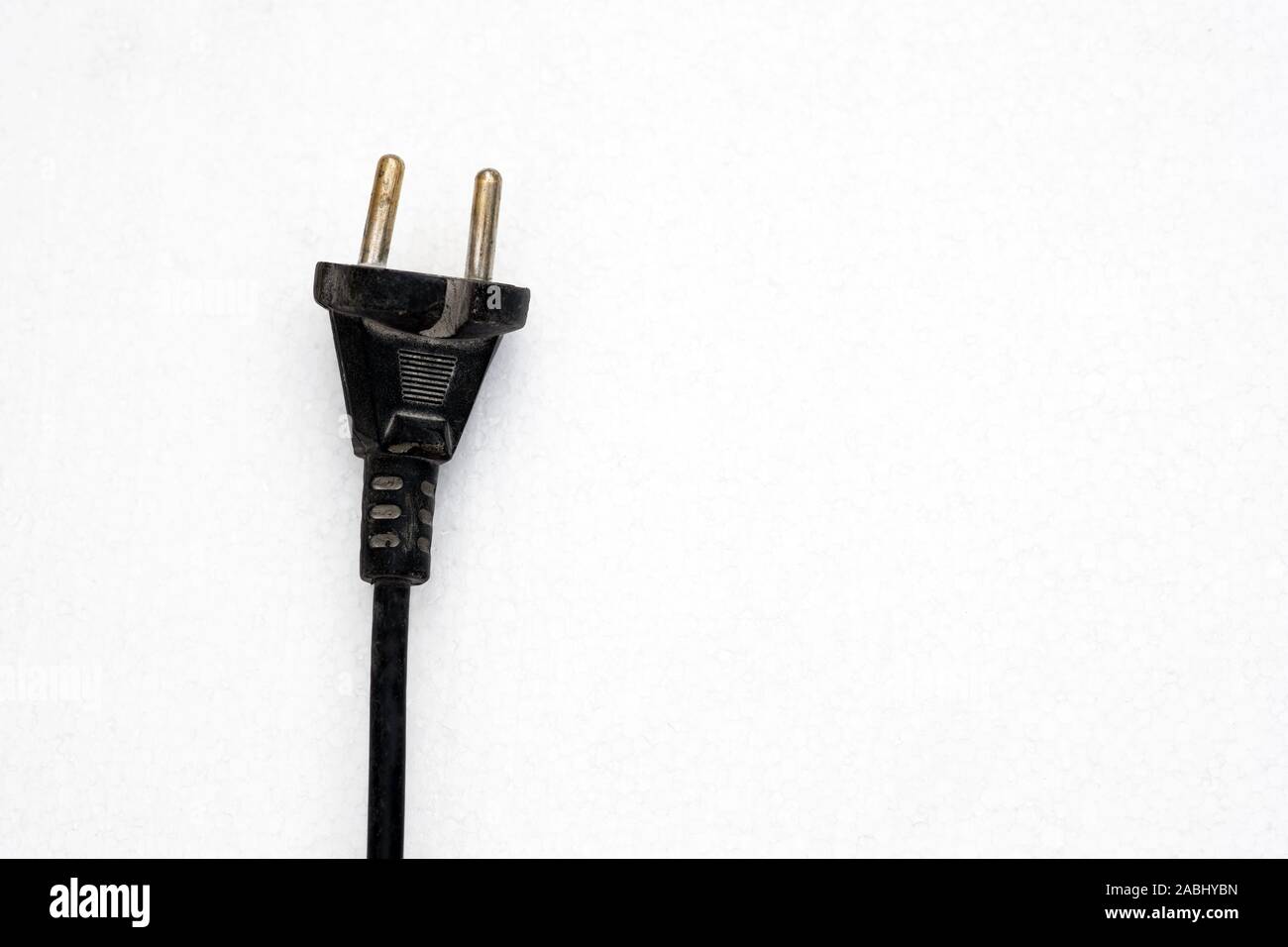 Electric plug close up. Black electric plug with wires on a white background. Old electric plug with cords. Stock Photo