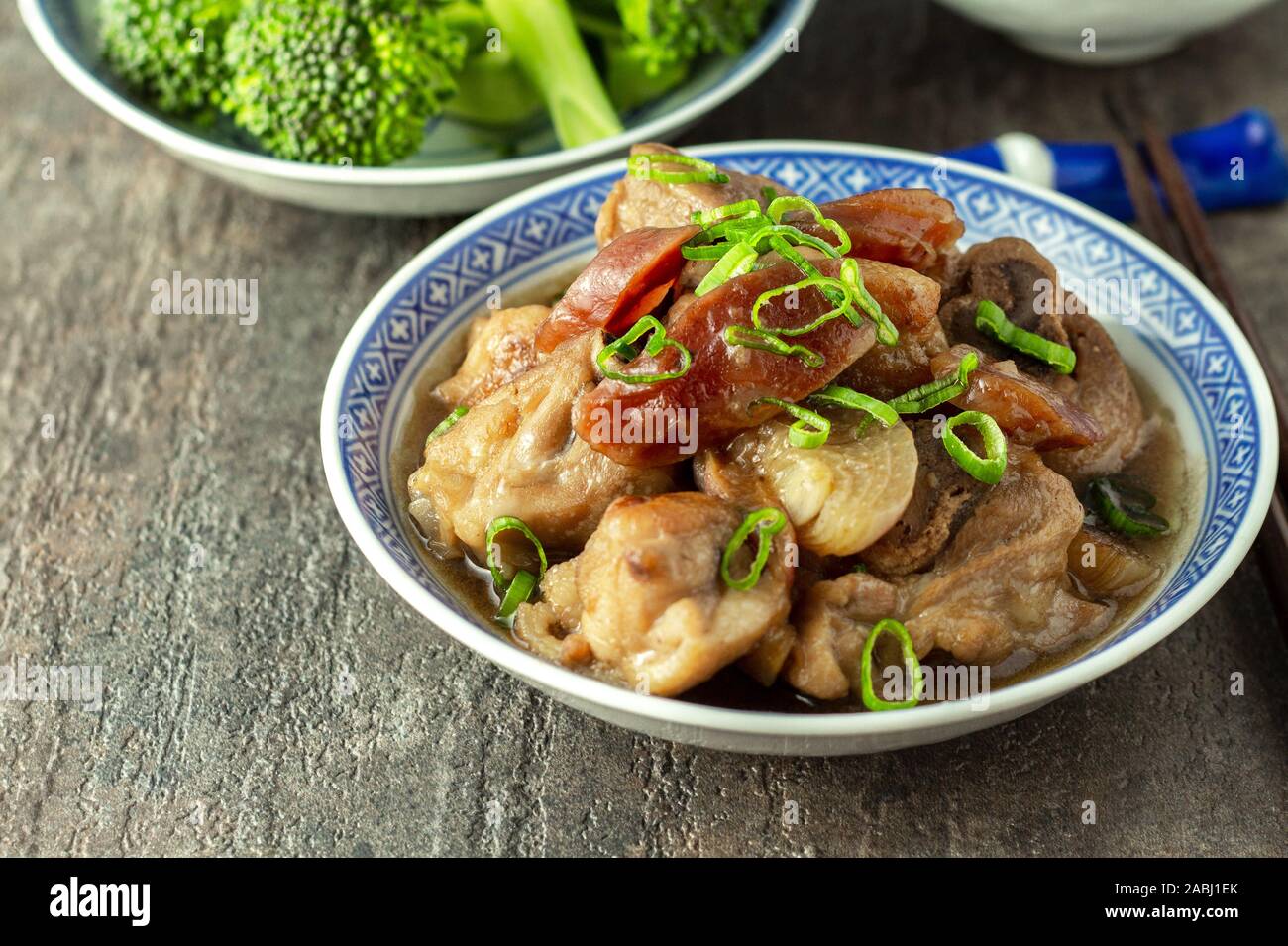 Chinese home cooking. Steamed chicken with Chinese sausage garnished with spring onion. Served with rice and vegetables. Free range, organic, natural Stock Photo